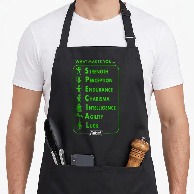 Tablier de cuisine noir avec motif vert S.P.E.C.I.A.L. et logo Fallout en bas.
