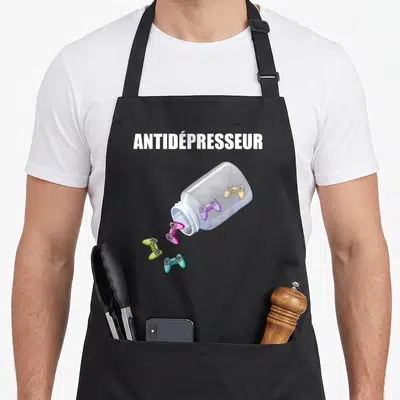 Tablier de cuisine noir avec une bouteille de manettes colorées et le mot Antidépresseur imprimé en blanc.
