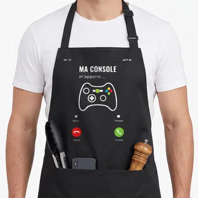Tablier de cuisine noir avec écran de téléphone affichant une manette de jeu et l'inscription Ma Console m'appelle.