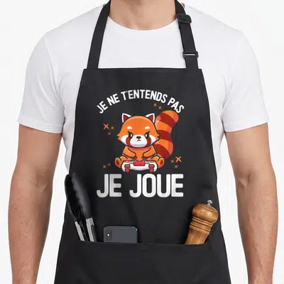 Tablier de cuisine noir avec illustration d'un panda roux tenant une manette blanche et rouge.