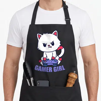 Tablier de cuisine noir avec illustration d'un chat blanc tenant une manette et le texte Gamer Girl en violet