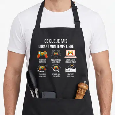 Tablier de cuisine noir avec six illustrations colorées de manettes et un ordinateur portable accompagnés de textes en français.