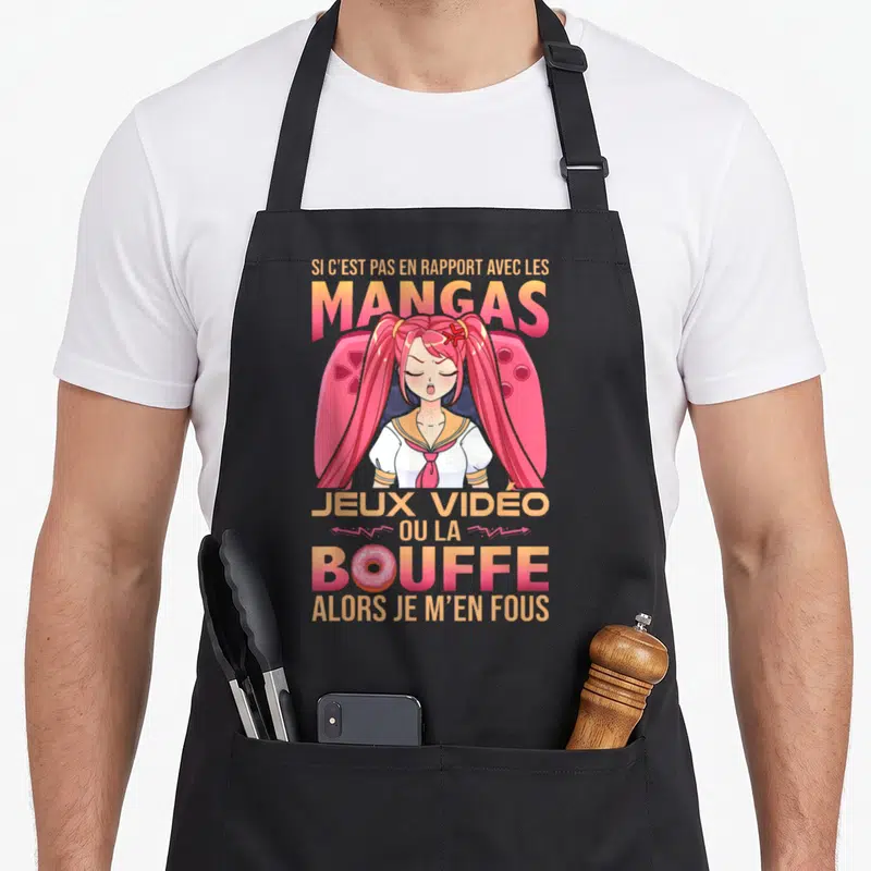 Tablier de cuisine noir avec illustration d'une fille aux cheveux roses et texte sur les mangas et la bouffe.