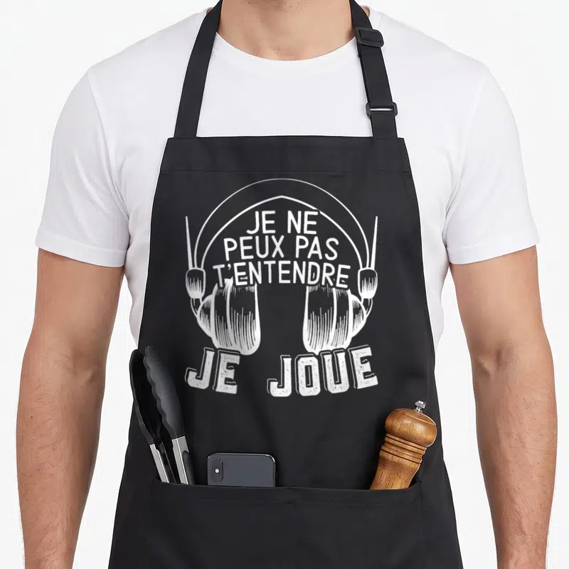Tablier de cuisine noir avec illustration blanche d'un casque audio et le texte Je ne peux pas t'entendre je joue.