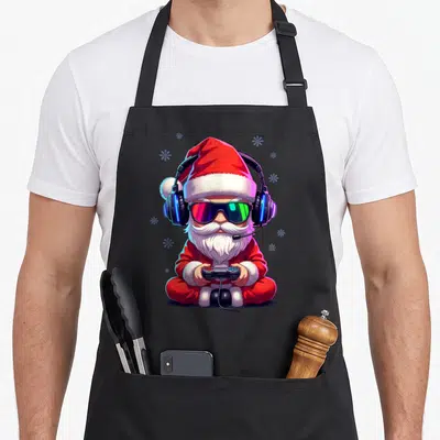 Tablier de cuisine noir avec illustration d'un Père Noël Gamer portant des lunettes de soleil et un casque audio.
