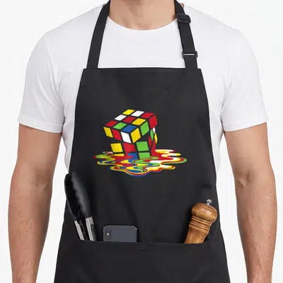 Tablier de cuisine noir avec un cube Rubik multicolore qui fond en taches ondulées sur le devant.