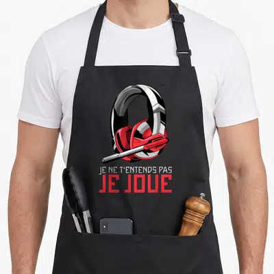 Tablier de cuisine noir avec illustration de casque audio rouge et blanc et texte Je ne t'entends pas je joue en dessous.