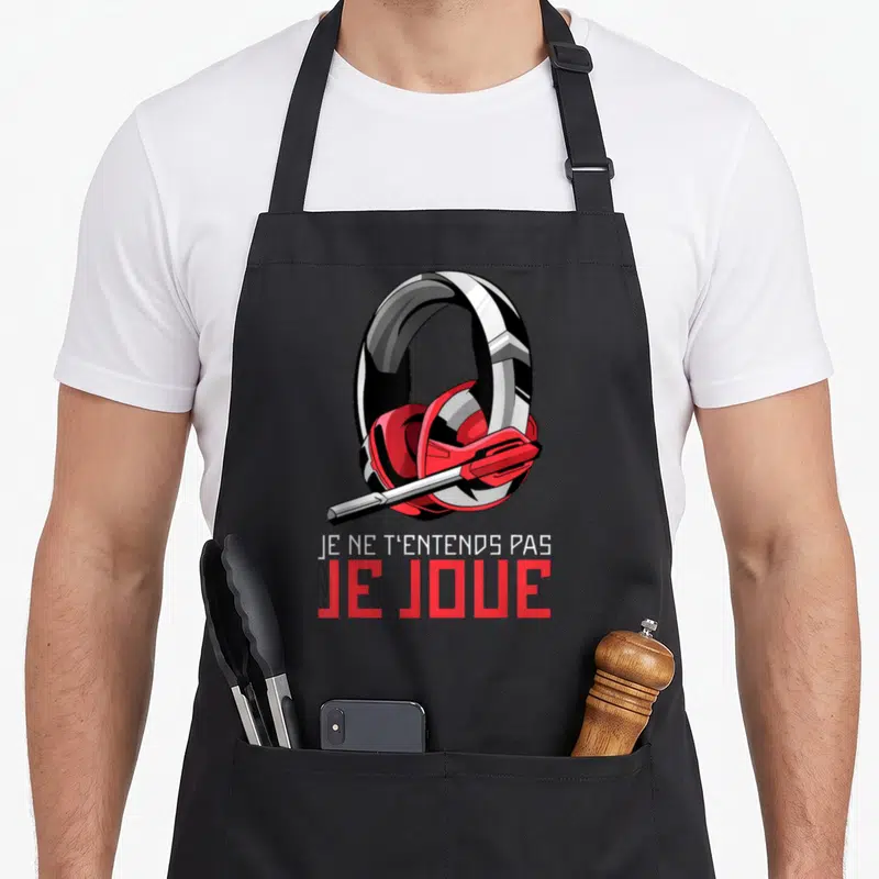 Tablier de cuisine noir avec illustration de casque audio rouge et blanc et texte Je ne t'entends pas je joue en dessous.