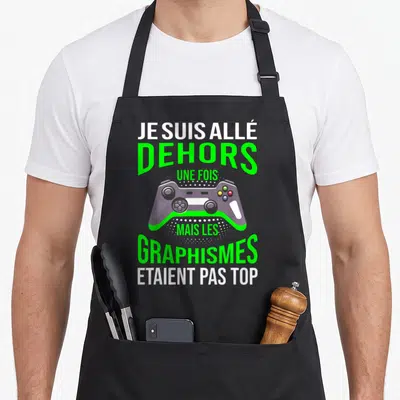 Tablier de cuisine noir avec illustration de manette de jeu et texte blanc vert je suis allé dehors une fois mais les graphismes étaient pas top