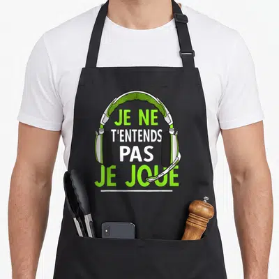 Tablier de cuisine noir avec illustration de casque gaming vert et blanc et texte humoristique sur le front.