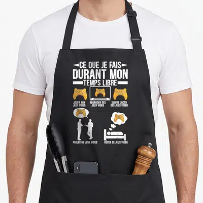 Tablier de cuisine noir avec illustration orange et blanche sur les loisirs gamer et les manettes de jeu.