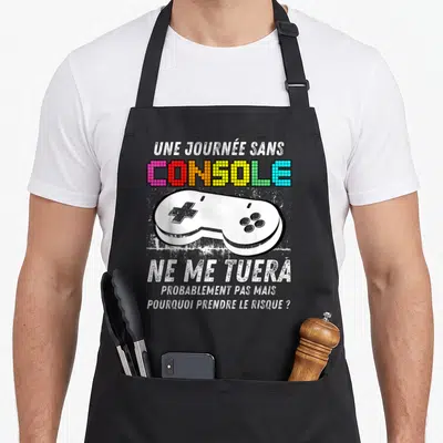Tablier de cuisine noir avec une manette de jeu vidéo blanche et le texte Une journée sans console ne me tuera probablement pas mais pourquoi prendre le risque ?