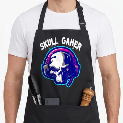 Tablier de cuisine noir avec illustration crâne portant un casque gamer aux couleurs néon et texte Skull Gamer.