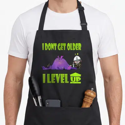 Tablier de cuisine noir avec un guerrier victorieux et un dragon violet aux couleurs vertes vives.