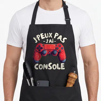 Tablier de cuisine noir avec illustration de manette rouge et texte J'peux pas j'ai console
