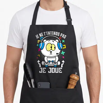Tablier de cuisine noir avec ours blanc portant un casque bleu et tenant une manette de jeu vidéo.