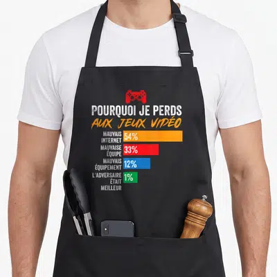 Tablier de cuisine noir avec un graphique humoristique sur les raisons de perdre aux jeux vidéo et une manette rouge.