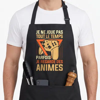 Tablier de cuisine noir avec une manette de jeu orange et le texte Je ne joue pas tout le temps parfois je regarde des animes.