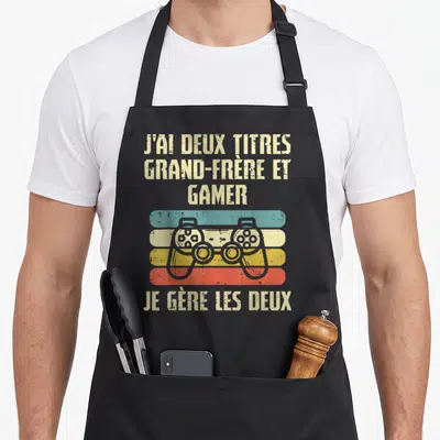 Tablier de cuisine noir avec manette de jeu rétro et texte J'ai deux titres grand-frère et gamer.