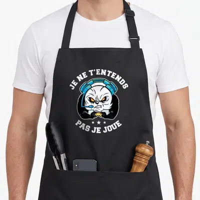 Tablier de cuisine noir avec un panda gamer portant des écouteurs et tenant une manette dorée.