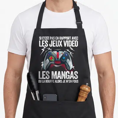 Tablier de cuisine noir avec une illustration de manette de jeu vidéo entourée d'éclairs et un texte humoristique en blanc.