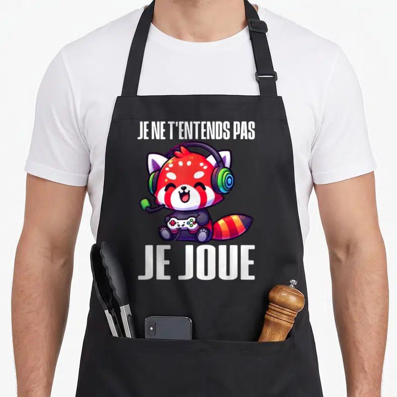 Tablier de cuisine noir avec un panda roux mignon portant des écouteurs et tenant une manette de jeu vidéo.