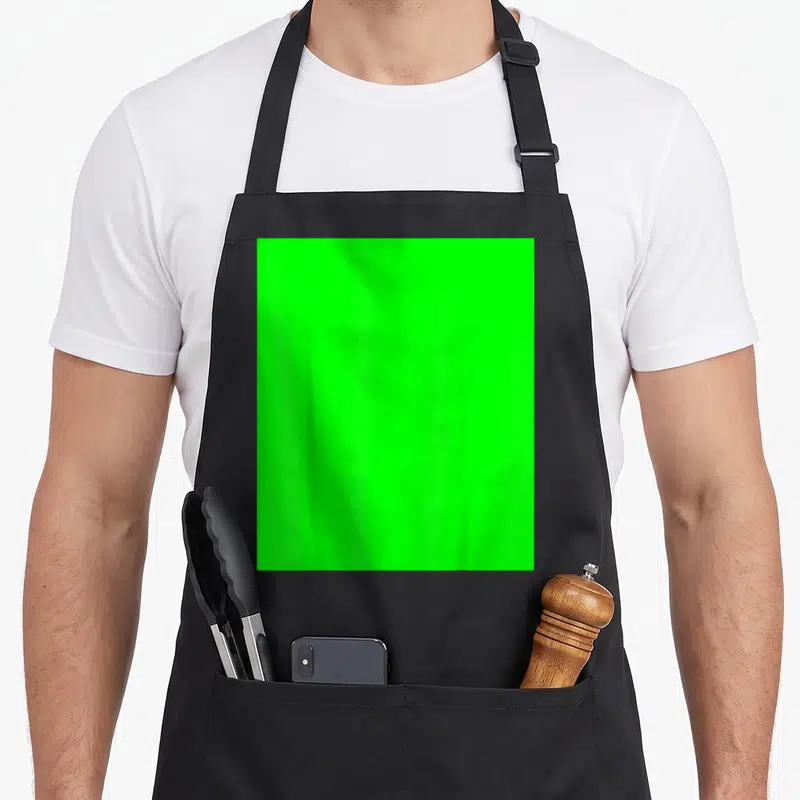 Tablier de cuisine noir avec un grand rectangle vert fluorescent imitant un écran vert de studio de streaming.