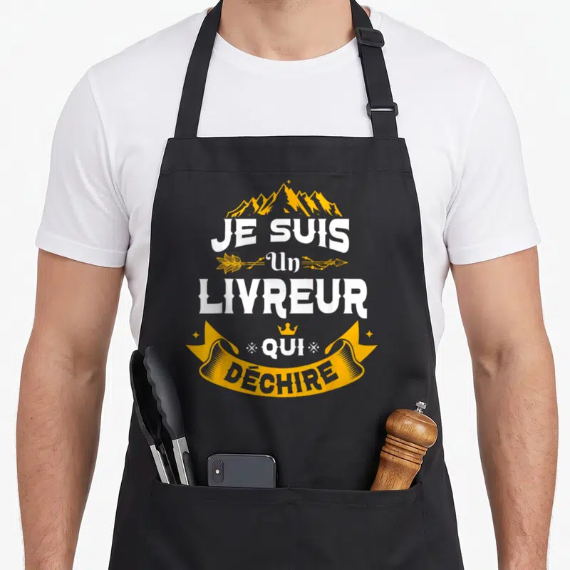 Tablier de cuisine noir avec inscription Je Suis Un Livreur Qui Déchire en blanc et jaune, orné de montagnes et d'une bannière.