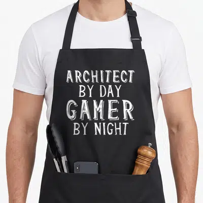 Tablier de cuisine noir avec inscription blanche « ARCHITECT BY DAY GAMER BY NIGHT » en typographie manuscrite.