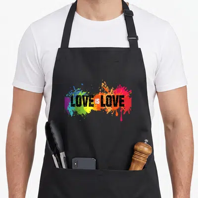 Tablier de cuisine noir avec inscription Love is Love sur éclaboussures de couleurs arc-en-ciel.
