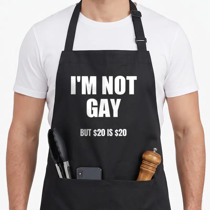 Tablier de cuisine noir avec le texte blanc I'm Not Gay But $20 Is $20 centré sur le devant.