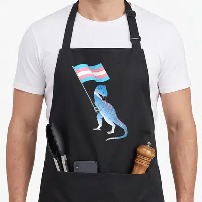 Tablier de cuisine noir avec illustration d'un dinosaure bleu tenant le drapeau transgenre.