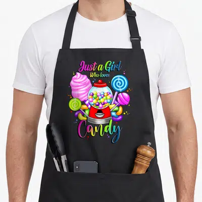 Tablier de cuisine noir avec machine à bonbons multicolore, lollipops et texte arc-en-ciel.