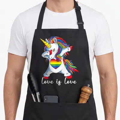 Tablier de cuisine noir avec une licorne blanche en train de faire un dab, un cœur aux couleurs de l'arc-en-ciel et le texte love is love en bas.