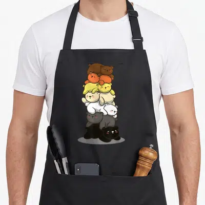 Tablier de cuisine noir avec une illustration de plusieurs ours kawaii empilés aux teintes variées représentant le drapeau de la fierté.