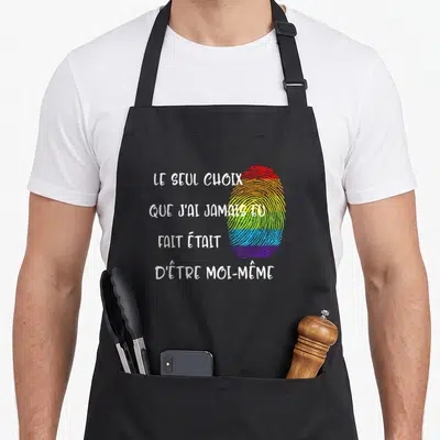 Tablier de cuisine noir avec une empreinte digitale arc-en-ciel et un texte blanc affirmant l'authenticité.