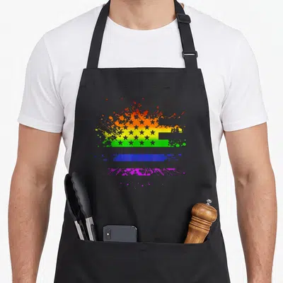 Tablier de cuisine noir avec un drapeau américain aux couleurs de l'arc-en-ciel et effet éclaboussure.