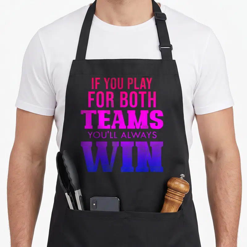 Tablier de cuisine noir avec le texte If You Play For Both Teams Youll Always Win en rose et violet