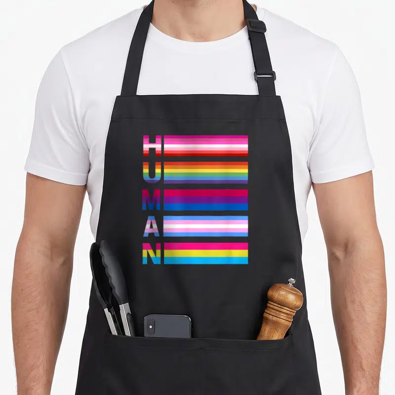 Tablier de cuisine noir avec le mot Human composé de bandes colorées représentant divers drapeaux de la fierté LGBT.