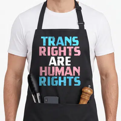 Tablier de cuisine noir avec le texte Trans Rights Are Human Rights en typographie colorée.