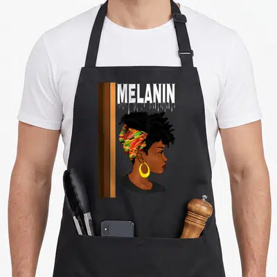 Tablier de cuisine noir avec illustration profil femme noire foulard africain et texte Mélanin drippin en haut.