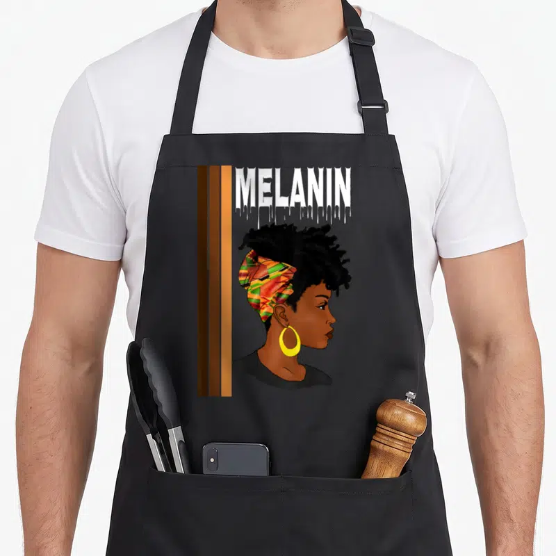 Tablier de cuisine noir avec illustration profil femme noire foulard africain et texte Mélanin drippin en haut.