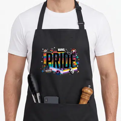 Tablier de cuisine noir avec un grand motif Pride Marvel Est 39 aux couleurs vives et aux étoiles scintillantes.
