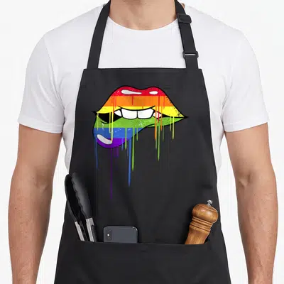 Tablier de cuisine noir avec lèvres arc-en-ciel aux couleurs du drapeau et effet de peinture qui coule.
