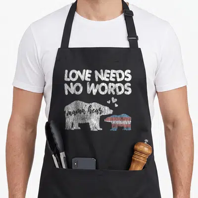 Tablier de cuisine noir avec illustration d'une ours et du texte Love Needs No Words en blanc.