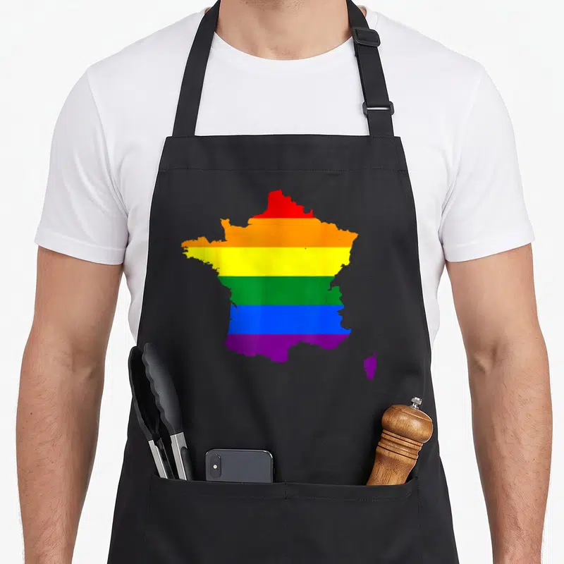 Tablier de cuisine noir avec une carte de France colorée aux bandes arc-en-ciel du drapeau fierté.