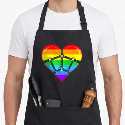 Tablier de cuisine noir avec un cœur arc-en-ciel ceinturé par un harnais noir BDSM.