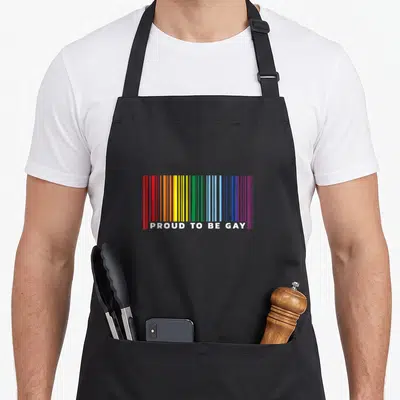 Tablier de cuisine noir avec un barcode arc-en-ciel et le texte Proud to be Gay en blanc.