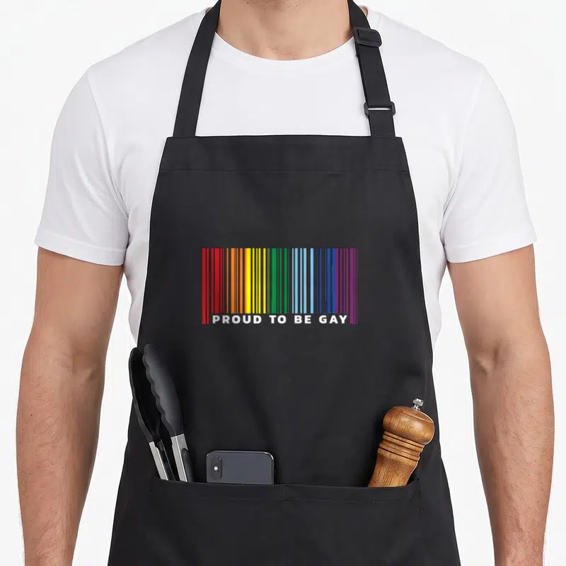 Tablier de cuisine noir avec un barcode arc-en-ciel et le texte Proud to be Gay en blanc.