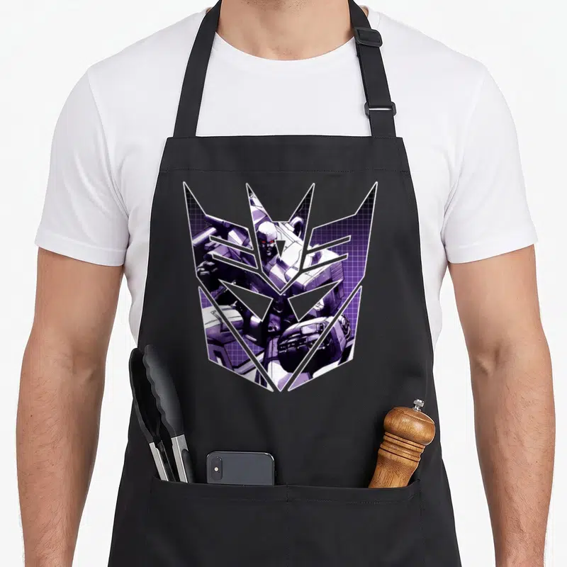 Tablier de cuisine noir avec le logo Decepticon et une illustration de Megatron en violet sur fond quadrillé.